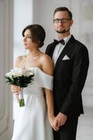 groom in a black suit tie and the bride in a bright studio photo