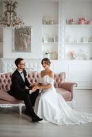 groom in a black suit tie and the bride in a bright studio photo