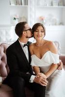 groom in a black suit tie and the bride in a bright studio photo