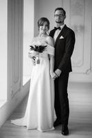 groom in a black suit tie and the bride in a bright studio photo