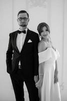 groom in a black suit tie and the bride in a bright studio photo