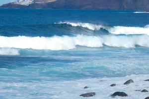 Large waves crashing against the rocks in the ocean photo