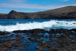 Large waves crashing against the rocks in the ocean photo