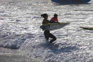 joven Atletas practicando el agua deporte de surf foto