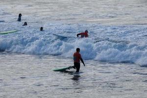 joven Atletas practicando el agua deporte de surf foto