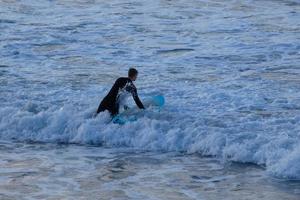 joven Atletas practicando el agua deporte de surf foto