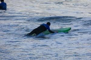 joven Atletas practicando el agua deporte de surf foto