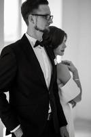 groom in a black suit tie and the bride in a bright studio photo