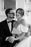 groom in a black suit tie and the bride in a bright studio photo