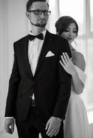 groom in a black suit tie and the bride in a bright studio photo