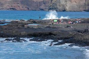 grande olas estrellarse en contra el rocas en el Oceano foto