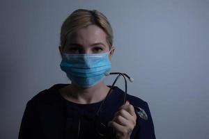 an attractive young woman wears a paper face mask to protect herself from the H1N1 Virus, isolated on white, with room for your text photo