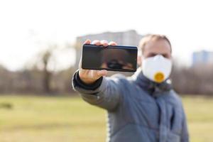 asiático hombre vistiendo el cara máscara debido a aire contaminación - joven adulto en parque con contaminación máscara - persona proteger desde aire contaminación o coronavirus o covid-19 por vistiendo mascarilla. foto