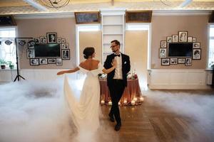 the first dance of the bride and groom inside a restaurant photo