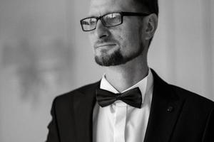 groom in a black suit with a bow photo