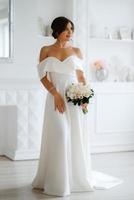 brunette bride in a tight wedding dress in a bright studio photo