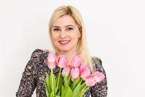 mujer con primavera flor ramo. contento sorprendido modelo mujer oliendo flores de la madre día. primavera foto