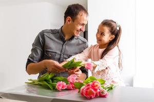 Father and daughter holding a bouquet of tulips photo