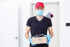 Delivery man holding cardboard boxes in rubber gloves and medical mask. copy space. Fast and free Delivery transport . Online shopping and Express delivery photo