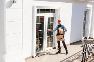 Delivery man delivering food to home - online grocery shopping service concept photo