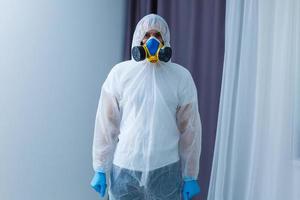 Man in protective suit, a mask and a respirator. photo