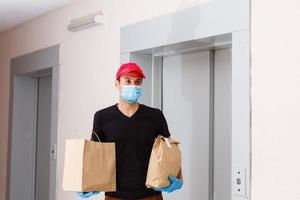 Delivery man holding cardboard boxes in medical rubber gloves. Quarantine. Coronavirus. door delivery photo