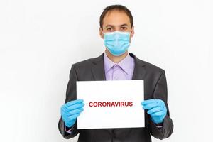 Close up of a businessman in a suit wearing Protective face mask, get ready for Coronavirus and pm 2.5 fighting against gray background. Healthcare concept. photo