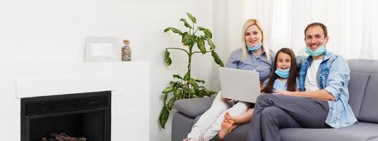 Quarantine time Family in protective masks at living room together. photo