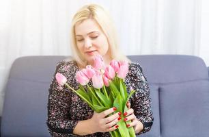 mujer con primavera flor ramo. contento sorprendido modelo mujer oliendo flores de la madre día. primavera foto