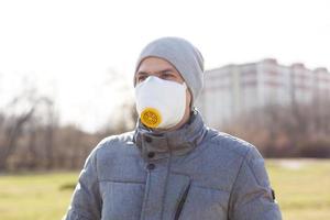 un hombre vistiendo un máscara en el calle. proteccion en contra virus y apretón foto