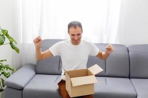 Happy man with an open box in an apartment photo