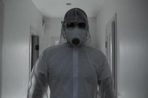 Scientist in protective wear, glasses and respirator photo