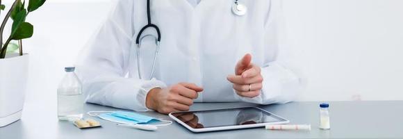 médico con tableta, en línea consulta foto