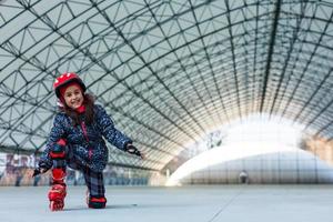 little girl rollerblading on roller rink photo