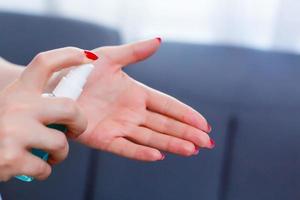 Young girl cleaning hands with alcohol sanitizer photo