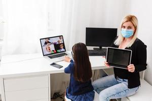 Pretty stylish schoolgirl studying homework math during her online lesson at home, social distance during quarantine, self-isolation, online education concept, home schooler photo