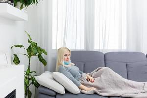 A European woman, has a virus and a cold, is sitting in a medical mask. photo