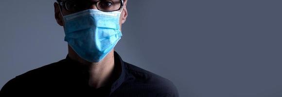 Strong man wearing mask to prevent flu virus and dust air pollution on white background photo