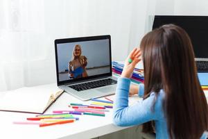 Young caucasian girl studying at home with online courses during the coronavirus quarantine. Distance education concept photo