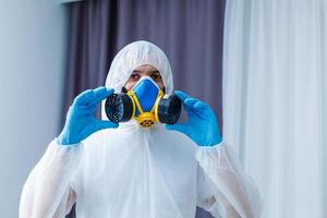 Man in protective clothing and a gasmask on a white background photo