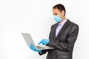 caucasian businessman with medical mask for coronavirus covid-19 protection working in office with covid 19 sign photo