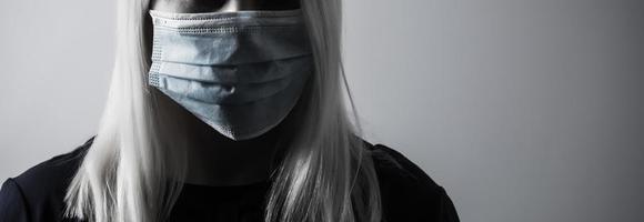 Young long-haired woman in protective medical mask photo