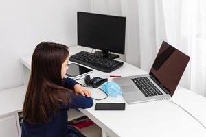 Pretty stylish schoolgirl studying homework math during her online lesson at home, social distance during quarantine, self-isolation, online education concept, home schooler photo