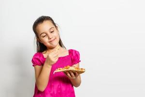 contento pequeño niña comiendo Pizza blanco antecedentes foto