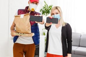 Delivery man holding paper bag with food on white background, food delivery man in protective mask photo