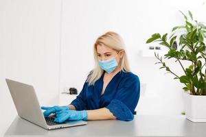 Woman in quarantine wearing protective mask and smart working photo