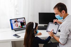 Pretty stylish schoolgirl studying homework math during her online lesson at home, social distance during quarantine, self-isolation, online education concept, home schooler photo