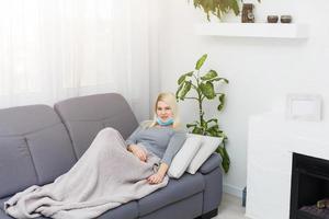 A European woman, has a virus and a cold, is sitting in a medical mask. photo