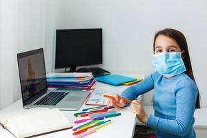 Young caucasian girl studying at home with online courses during the coronavirus quarantine. Distance education concept photo