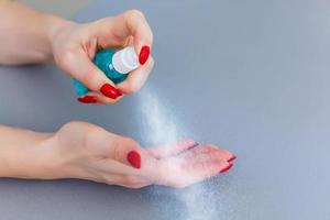 Young girl cleaning hands with alcohol sanitizer photo